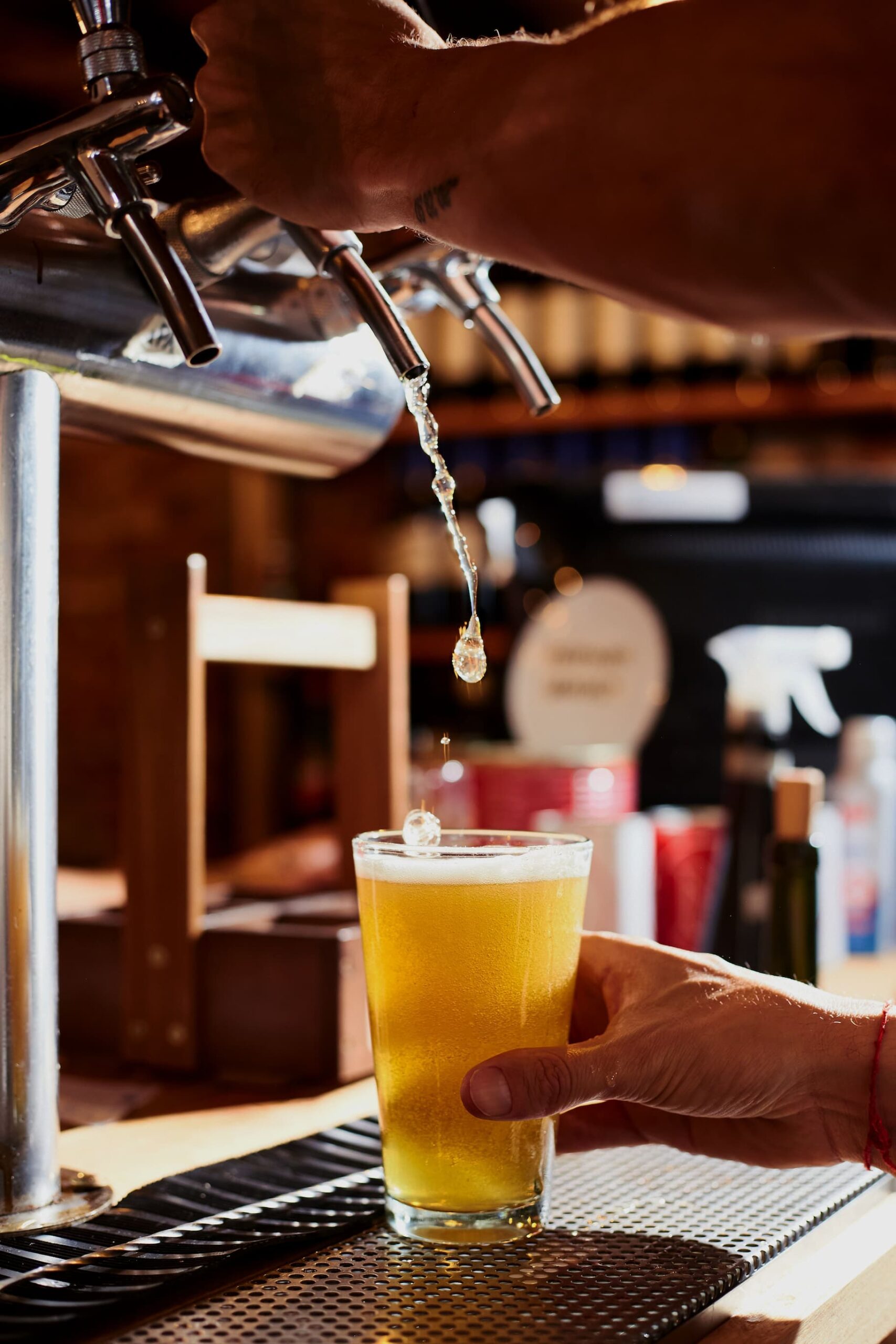 vertical-shot-of-a-man-drafting-a-beer-at-a-bar-2023-11-27-05-24-52-utc (1)
